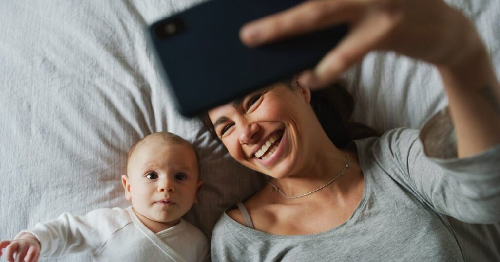 Email-Adresse für Baby anlegen. Mama macht Selfie mit Baby und schickt es.