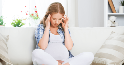 Ungebetene Ratschläge: Schwangere sitzt genervt auf dem Sofa