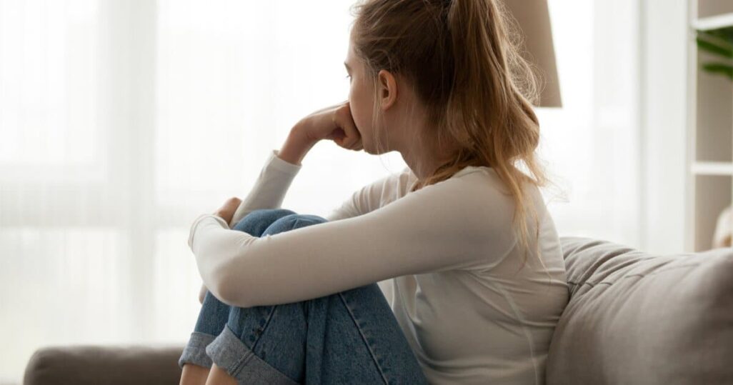 Depression in der Schwangerschaft: Frau dreht den Kopf weg und schaut traurig in die Leere