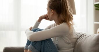 Depression in der Schwangerschaft: Frau dreht den Kopf weg und schaut traurig in die Leere