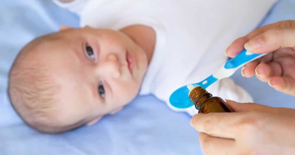 Ein Baby bekommt Vitamin-K-Tropfen auf einem Löffel