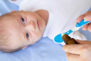 Ein Baby bekommt Vitamin-K-Tropfen auf einem Löffel