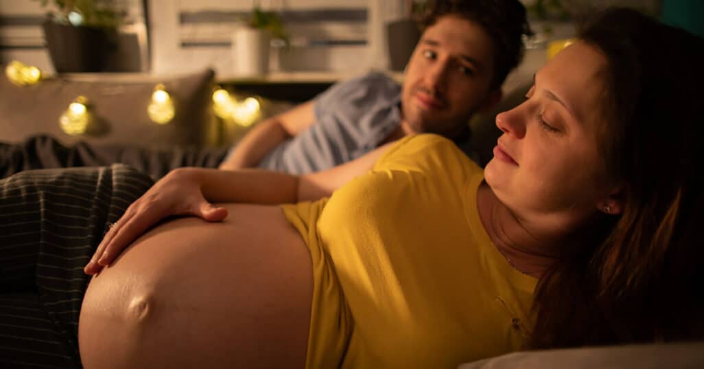 Hochschwangere Frau liegt im Bett - Hat sie einen Blasensprung?