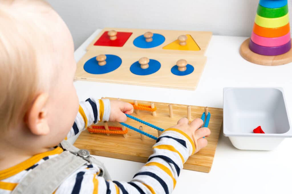 Kind spielt mit Montessori Material
