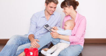 Familie mit Baby und Taschenrechner in der Hand