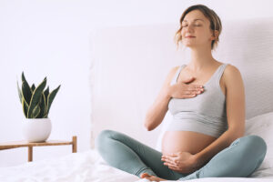 Schwangere macht Achtsamkeitsübungen
