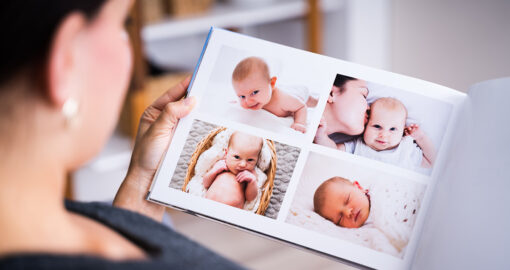Mutter, die sich Fotos im Babyalbum anschaut