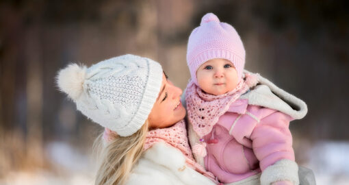 Mutter mit Baby im Arm im Winter