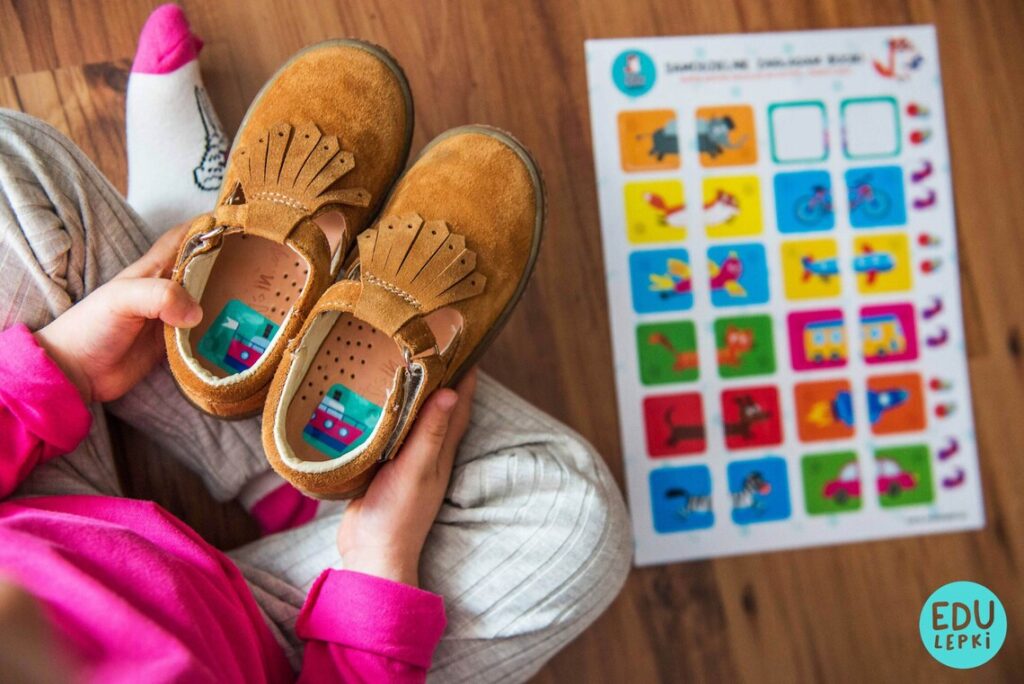 Kind mit Stickern in den Schuhen