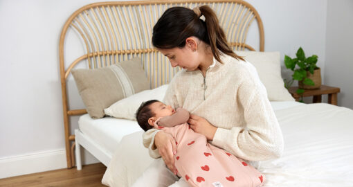 Baby im Babyschlafsack auf dem Arm ihrer Mutter
