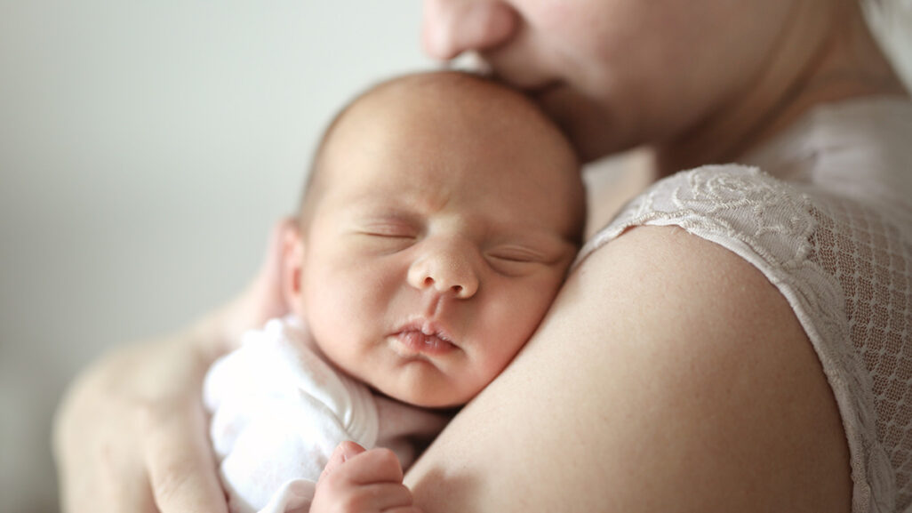 Schlafendes Baby im Arm seiner Mutter