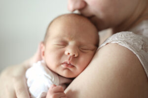 Schlafendes Baby im Arm seiner Mutter